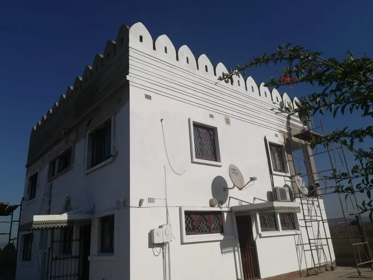 Project site — white crenellated building with arched windows and decorative facade
