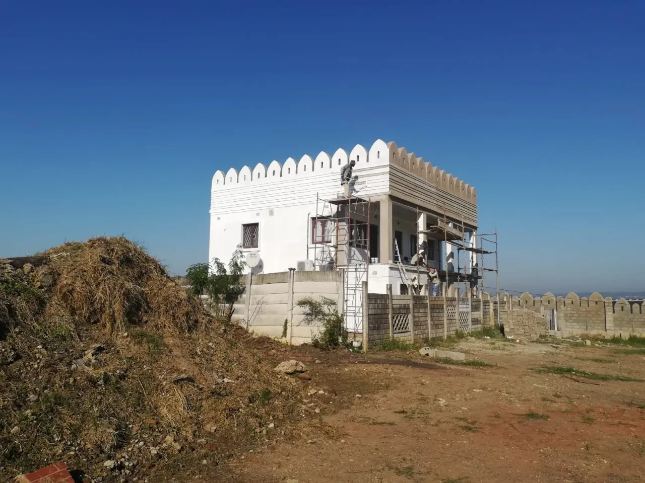 Project site — white fortified structure with Islamic architectural elements under construction