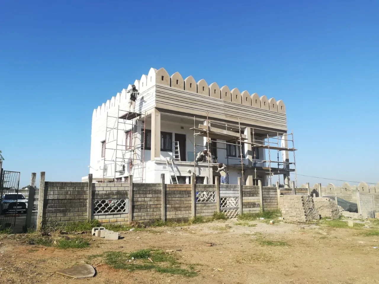 Project site — residential building under construction with crenellated roofline and decorative facade