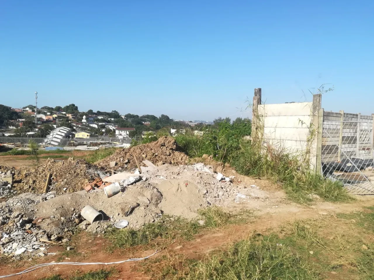 Project site — cleared site with rubble pile, fencing and Durban hillside