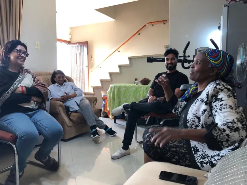Project site — community members gathered indoors, smiling portrait