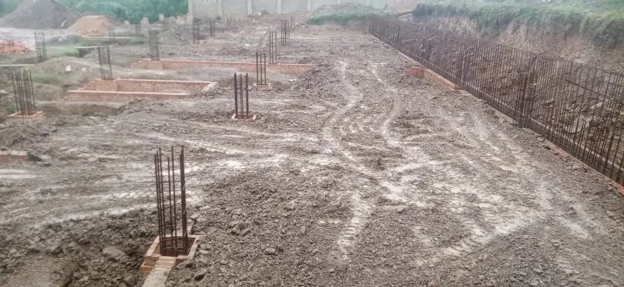 Project site — aerial view of large crenellated compound with cleared site and Durban cityscape