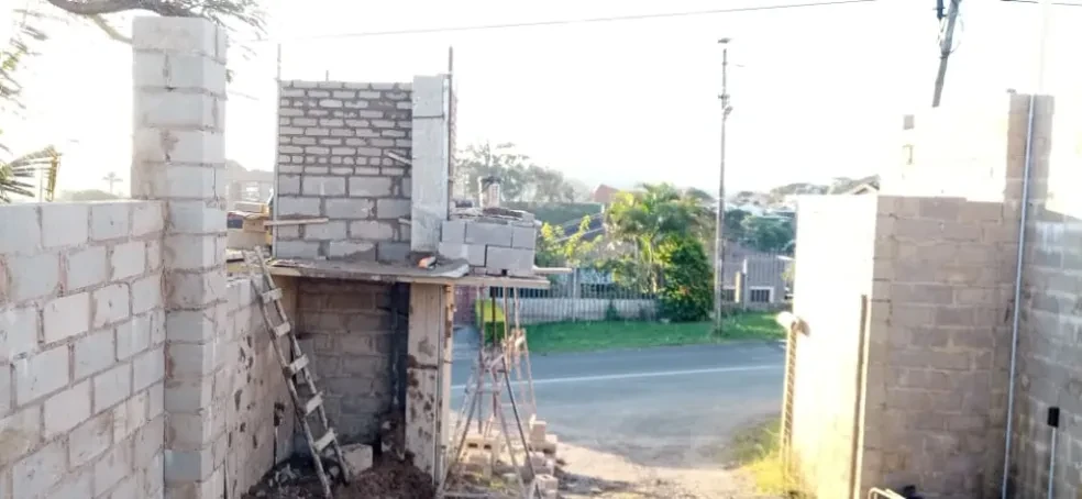 Project site — concrete block walls under construction with scaffolding, residential setting
