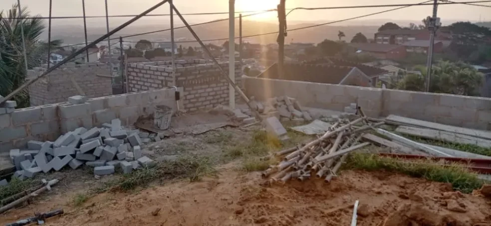 Project site — construction site at sunset with scaffolding, building materials and incomplete structure