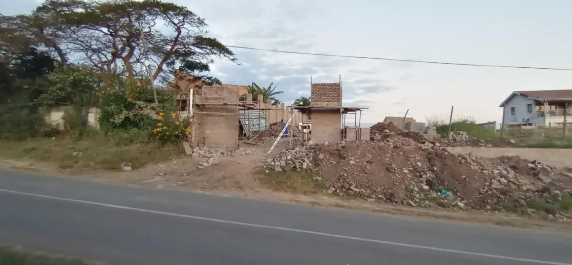 Project site — rural construction site with partially built structures, dirt and vegetation