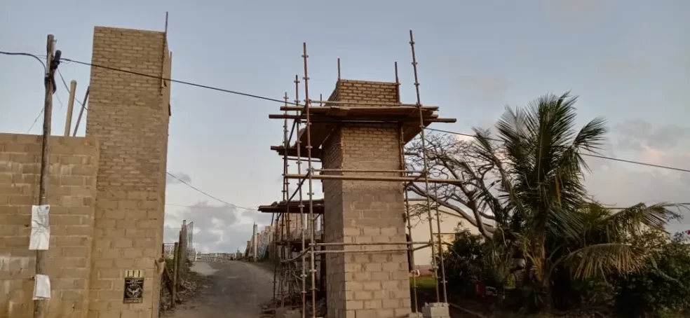 Project site — brick building under construction with scaffolding at golden hour