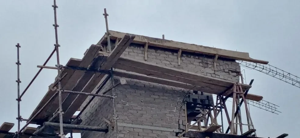 Project site — building under construction with scaffolding and timber formwork
