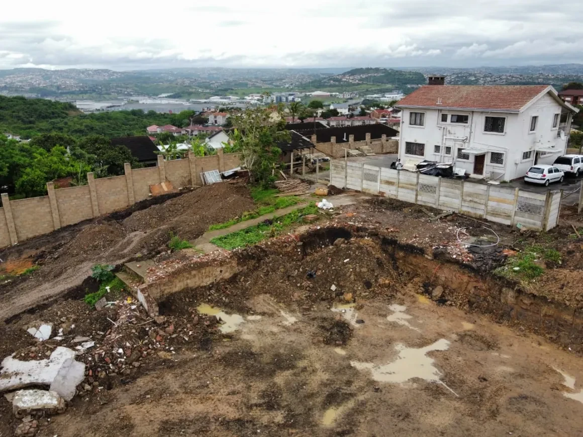 Project site — construction site with white house and panoramic view