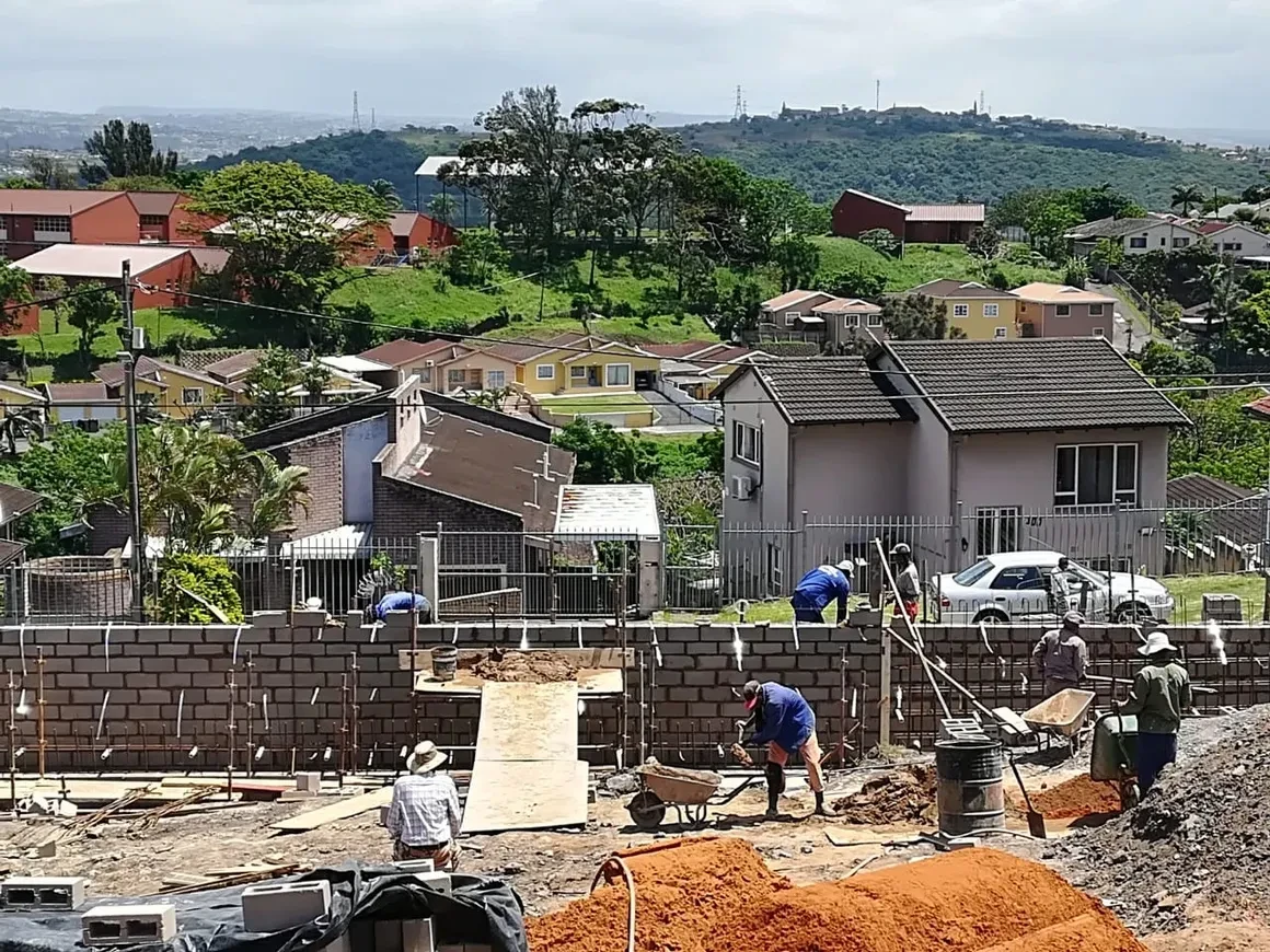 Project site — active construction with multiple workers and block walls