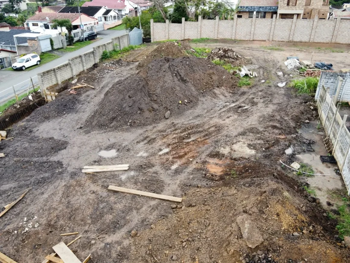 Project site — workers in trench excavating with pipe work