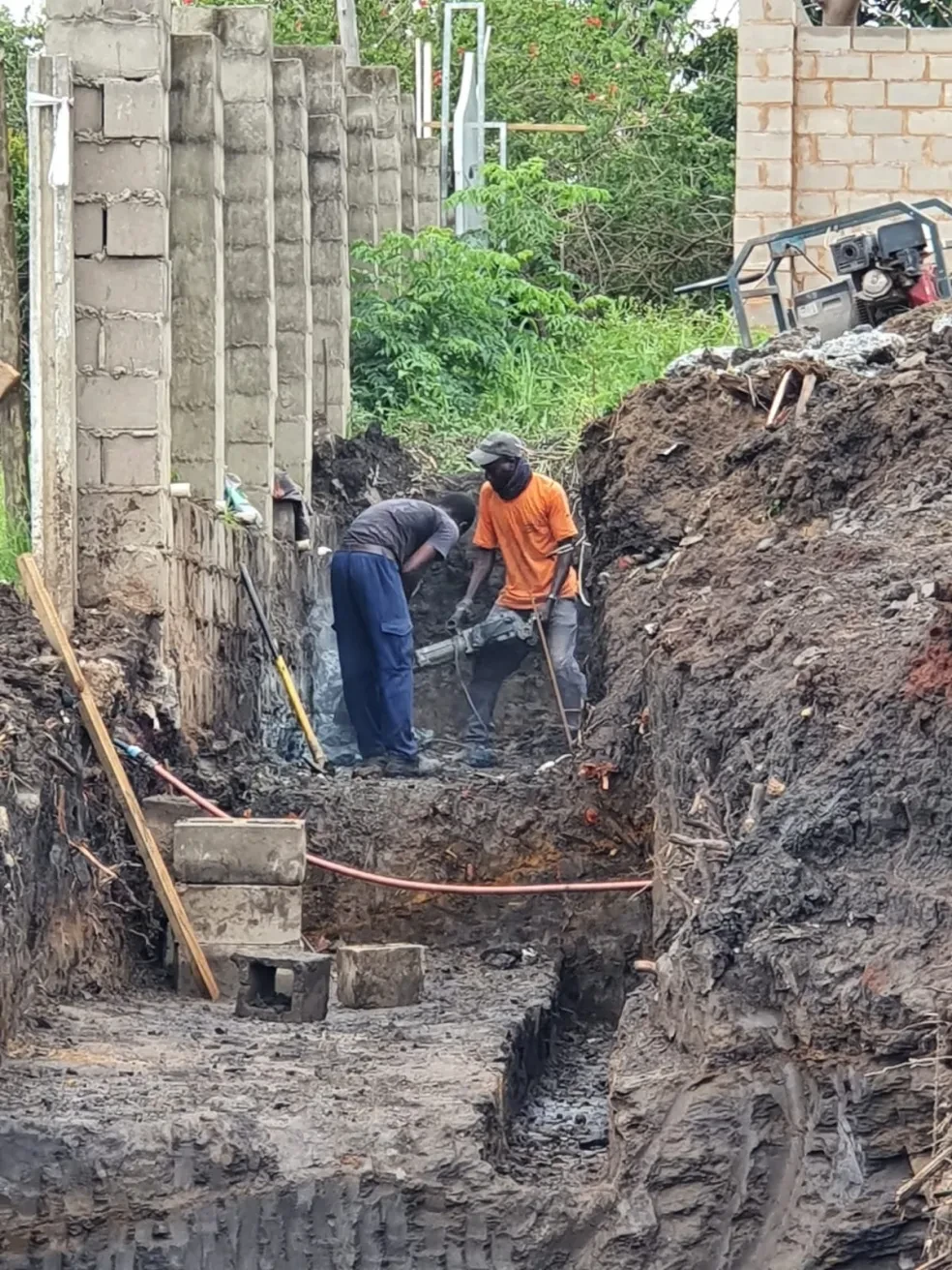 Project site — cleared site with mound of earth and perimeter walls
