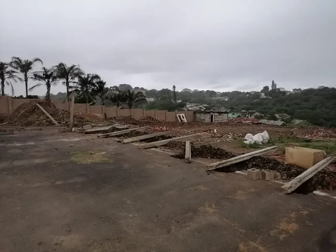 Project site — construction site with palm trees and residential buildings