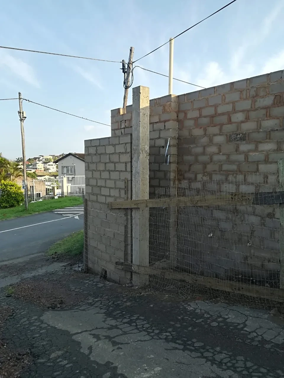Project site — unfinished brick structure with utility poles