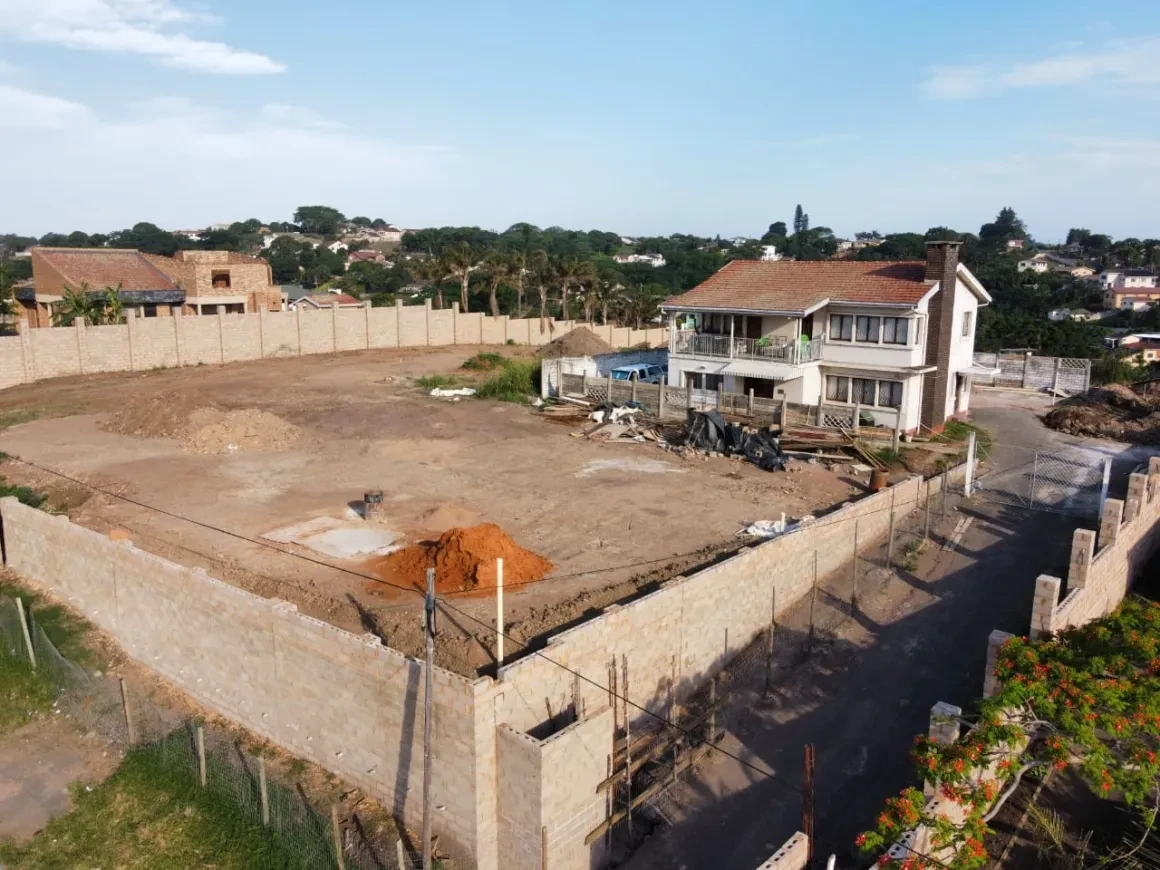 Project site — aerial view of levelled site with perimeter walls