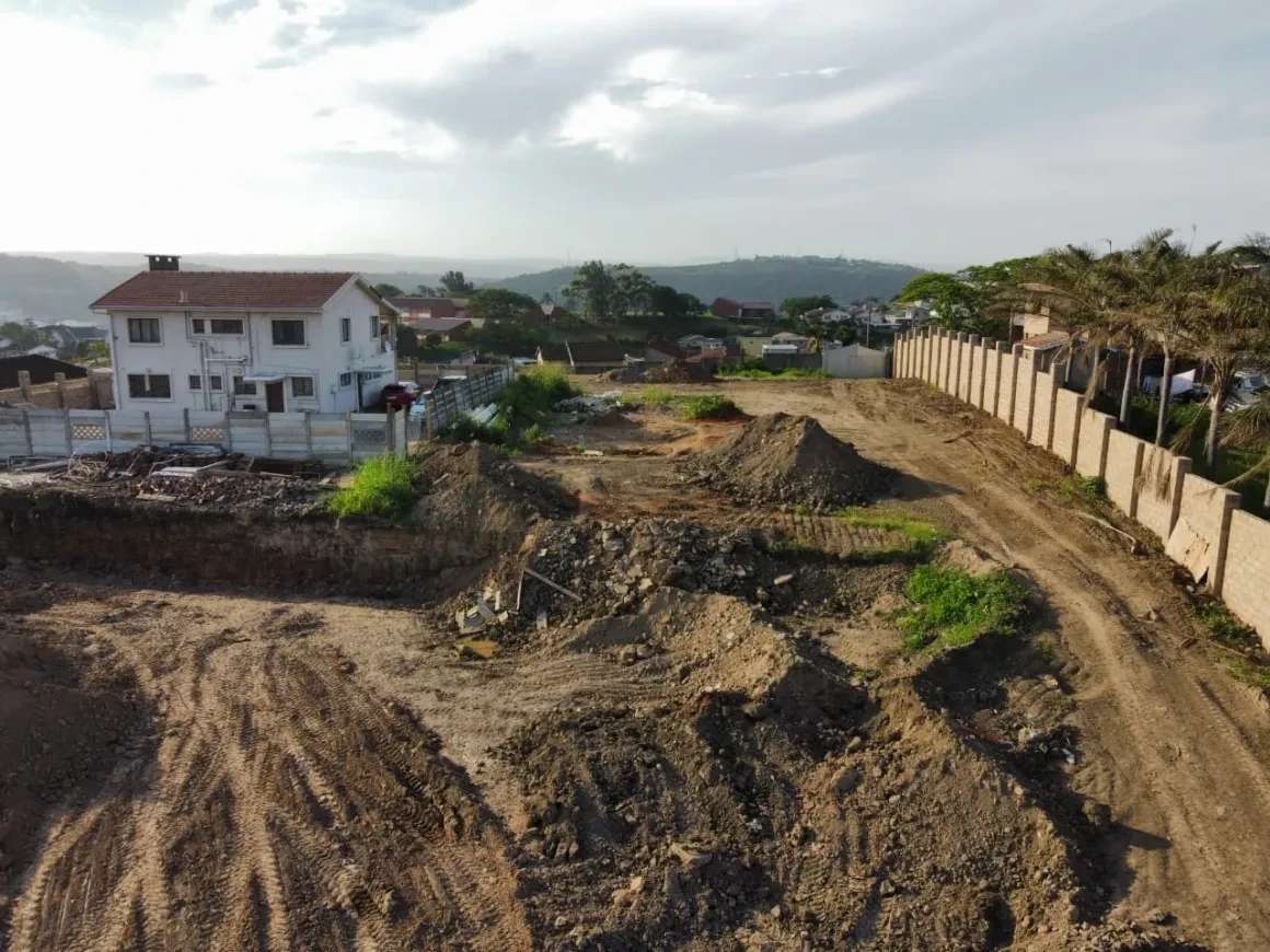 Project site — residential construction site with white house and excavated land