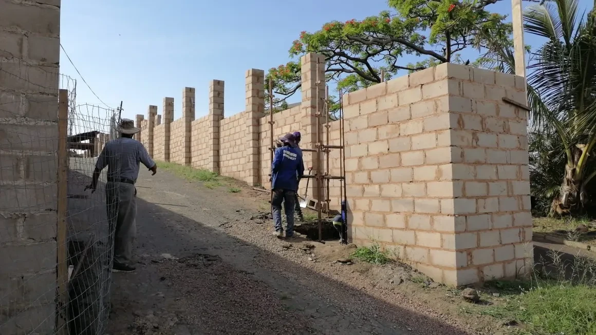 Project site — brick building under construction with workers and scaffolding