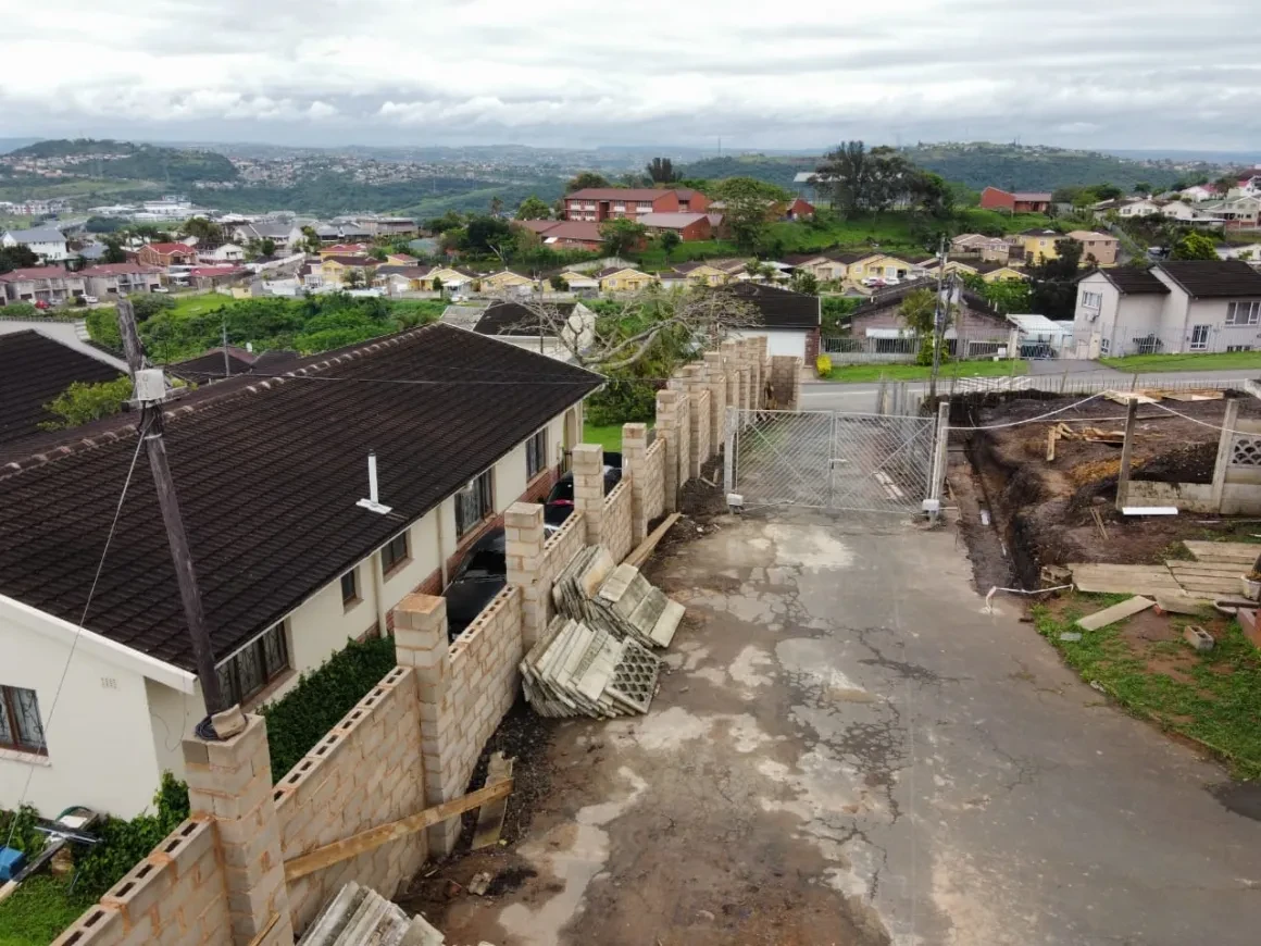 Project site — residential neighbourhood with houses under construction on hillside