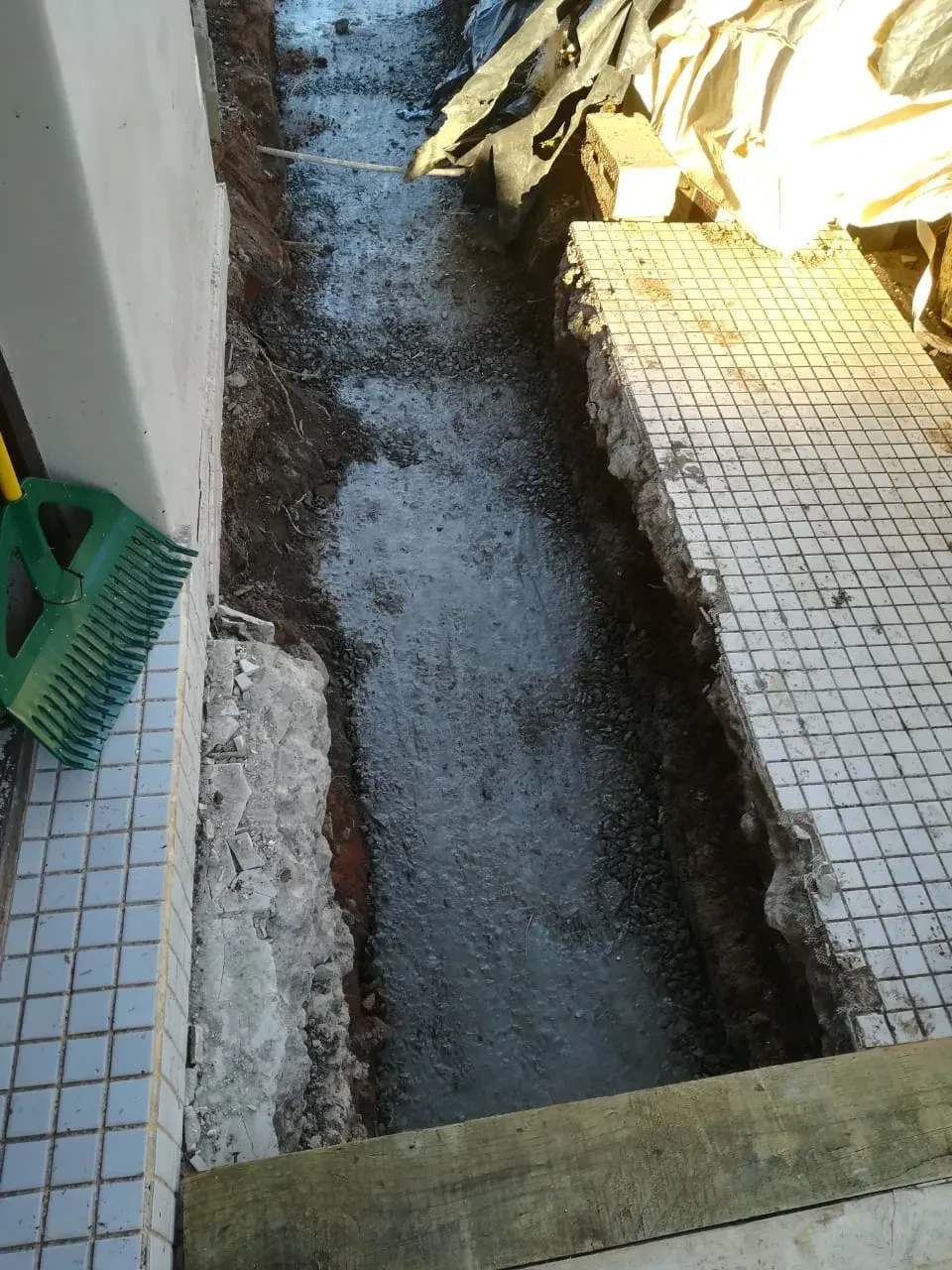 Project site — narrow corridor with tiled flooring and concrete walls under renovation