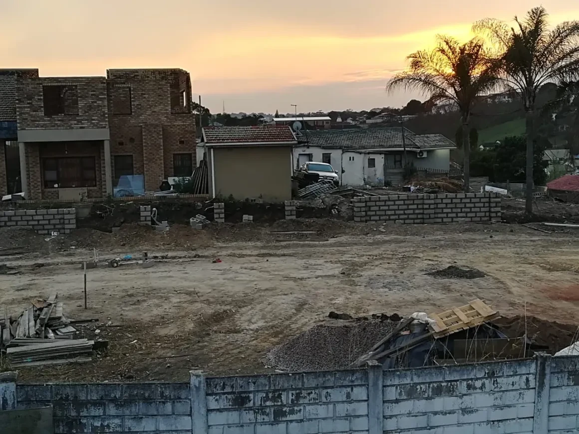 Project site — unfinished brick structure at dusk