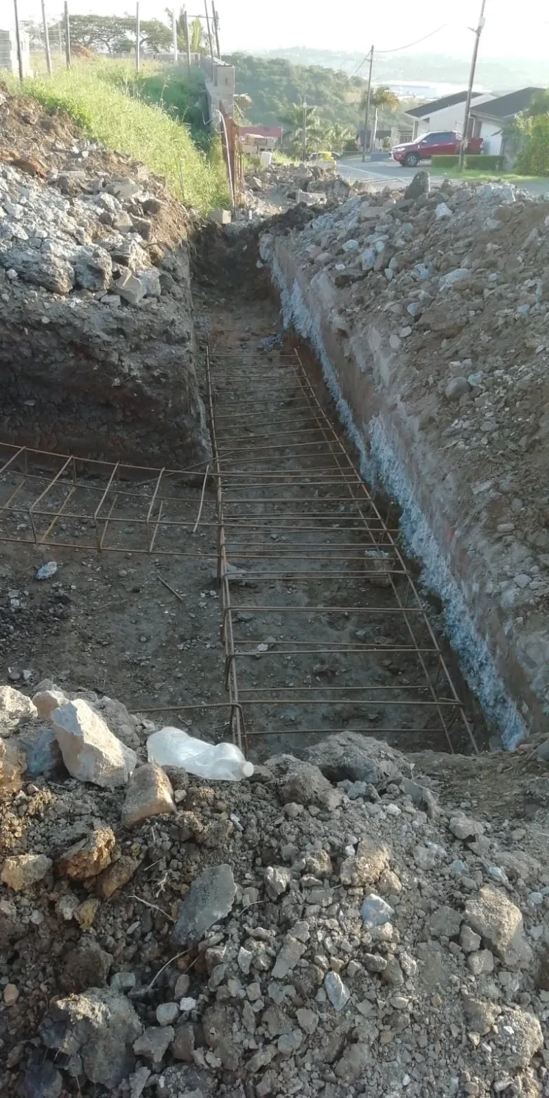 Project site — foundation trench with reinforcement steel and surrounding landscape