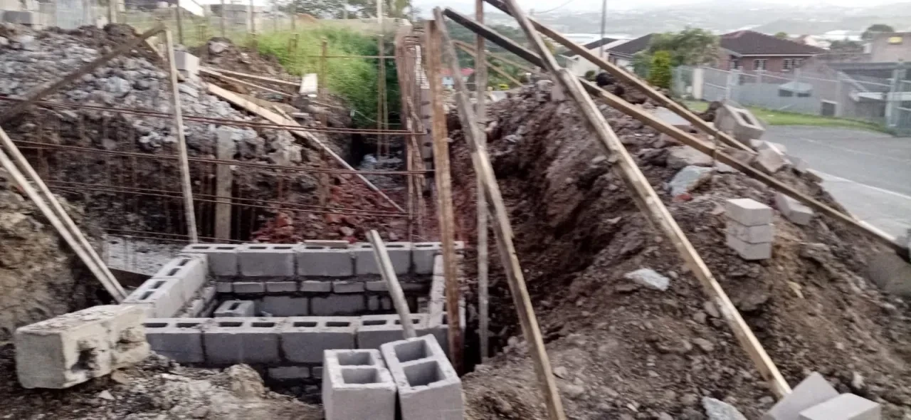 Project site — excavation with concrete blocks and wooden supports