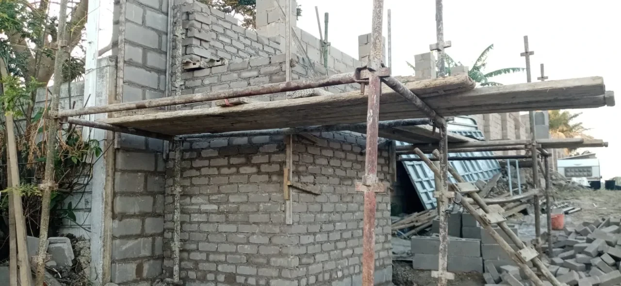 Project site — abandoned brick building with wooden scaffolding