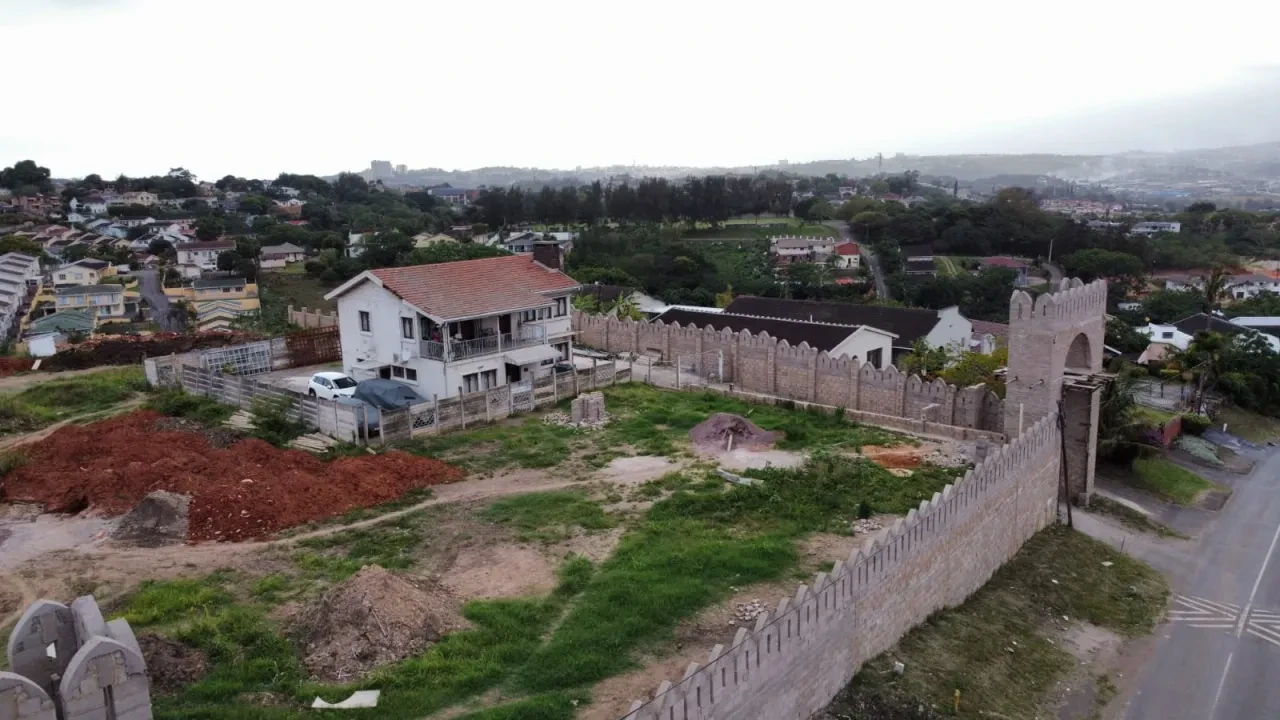 Project site — aerial view of crenellated perimeter wall with tower and open site