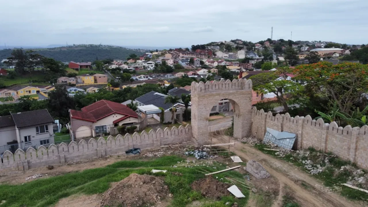 Project site — aerial view of crenellated boundary wall with white house and Durban valley