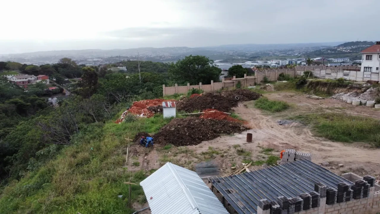 Project site — aerial view of arched gateway tower under construction with sand piles