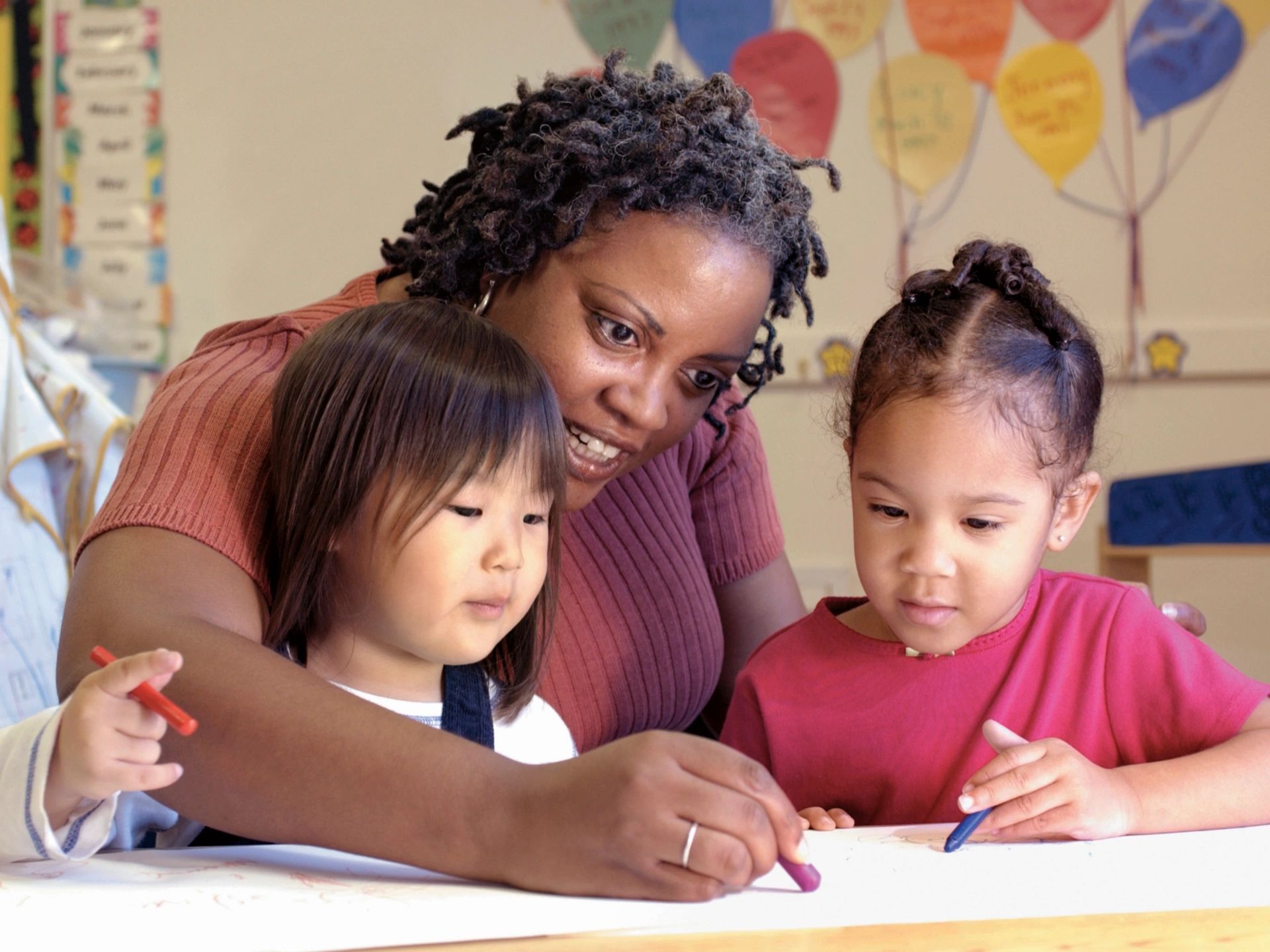 Teacher helping children with an activity